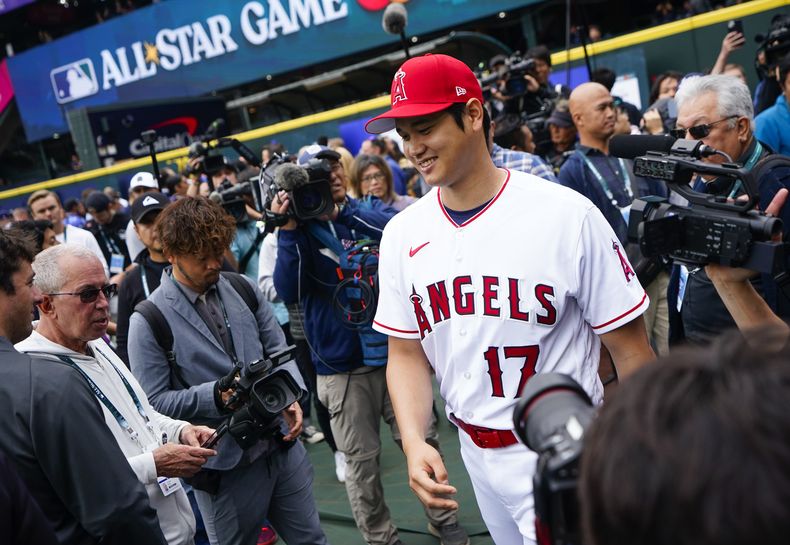 Shohei Ohtani jugador de Los Angelinos de Los Ángeles de la Liga Americana sonríe mientras camina hacia los jardines luego de atender a los medios en Seattle. Lunes 10 de julio de 2023. (AP Foto/Lindsey Wasson)