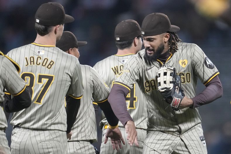 El lanzador de los Padres de San Diego, Alek Jacob, a la izquierda, celebra con el jardinero derecho Fernando Tatis Jr. después de que los Padres derrotaron a los Gigantes de San Francisco en San Francisco, el sábado 14 de septiembre de 2024. (AP Foto/Jeff Chiu)