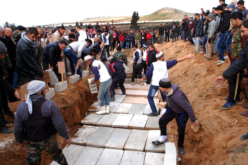 Sirios sepultan en una gran fosa los cad&aacute;veres de las v&iacute;ctimas del estallido de un coche bomba en la aldea de al-Kaffat en la provincia de Hama, en el centro de Siria, el viernes 10 de enero de 2014. Representantes de grupos opuestos al pres