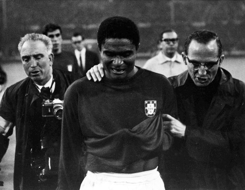 El astro portugu&eacute;s Eusebio llora mientras se retira de la cancha acompa&ntilde;ado despu&eacute;s de que Inglaterra derrotara 2-1 a Portugal en la semifinal del Mundial en Wembley, Londres, el 26 de julio de 1966. Eusebio, que naci&oacute; en Afric
