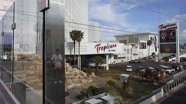 Una persona, reflejada en las ventanas, camina cerca del hotel Tropicana en Las Vegas, el martes 16 de mayo de 2023. (AP Foto/John Locher)