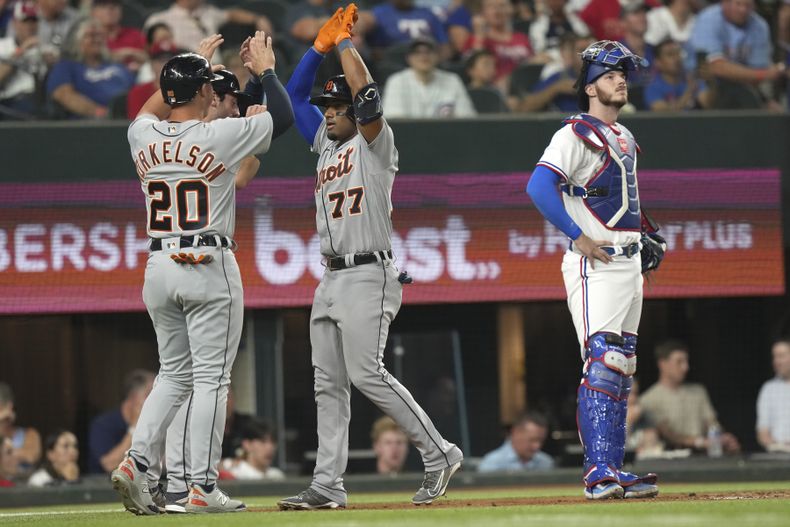 El cubano Andy Ibáñez celebra con su compañero de los Tigres de Detroit Spencer Torkelson después de que ambos anotaran en la tercera entrada del partido ante los Rangers de Texas, el lunes 26 de junio de 2023, en Arlington, Texas. El receptor de los Rangers es Jonah Heim. (AP Foto/LM Otero)