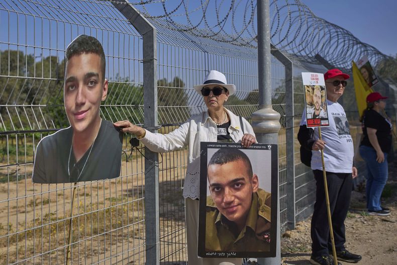 ARCHIVO - Varda Ben Baruch sostiene una foto de su nieto Edan Alexander, retenido como rehén en Gaza, junto a otros familiares que hablan por altoparlantes con la esperanza d que sus seres queridos les oigan, cerca de la frontera en Gaza en el kibbutz Nir Oz, en el sur de Israel, l 20 de abril de 2025. (AP Foto/Ohad Zwigenberg, Archivo)