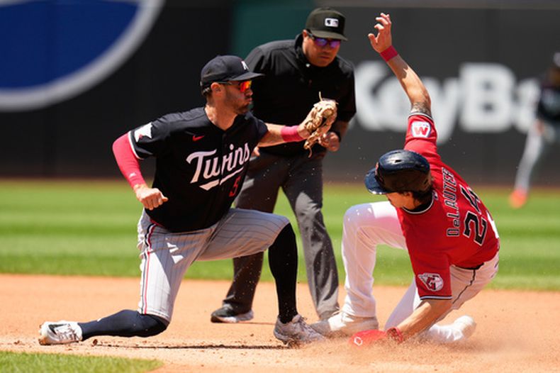 Chase DeLauter (24), de los Guardianes de Cleveland, se roba la segunda base ante el campo corto de los Mellizos de Minnesota, Ryan Kreidler (izquierda), en la cuarta entrada de un partido de béisbol en Cleveland, el jueves 23 de julio de 2026. (Foto AP/Sue Ogrocki)