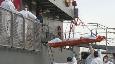 americateve | Varios marinos bajan un cad&aacute;ver de un barco de la Armada de Malta en el puerto de Valletta, Malta, despu&eacute;s de desembarcar a 143 sobrevivientes de un barco de traficantes de personas que naufrag&oacute; , con un saldo de 34 muertos, en una im