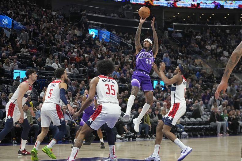 Jordan Clarkson (00), del Jazz de Utah, se alza para tomar un tiro ante la mirada de los jugadores de los Wizards de Washington, durante la segunda mitad del juego de baloncesto de la NBA, el lunes 4 de marzo de 2024, en Salt Lake City. (AP Foto/Rick Bowmer)