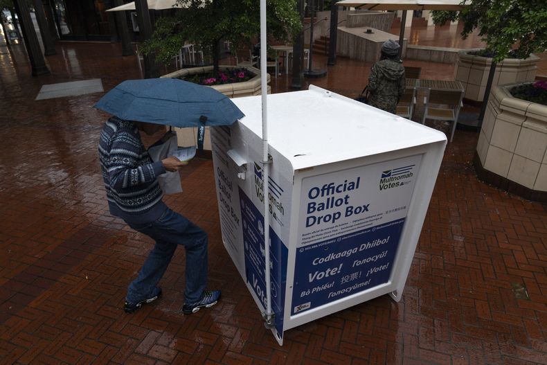 Una persona deja su boleta en un buzón electoral en Pioneer Square durante la votación primaria, el martes 21 de mayo de 2024, en Portland, Oregon. (AP Foto/Jenny Kane, Archivo)