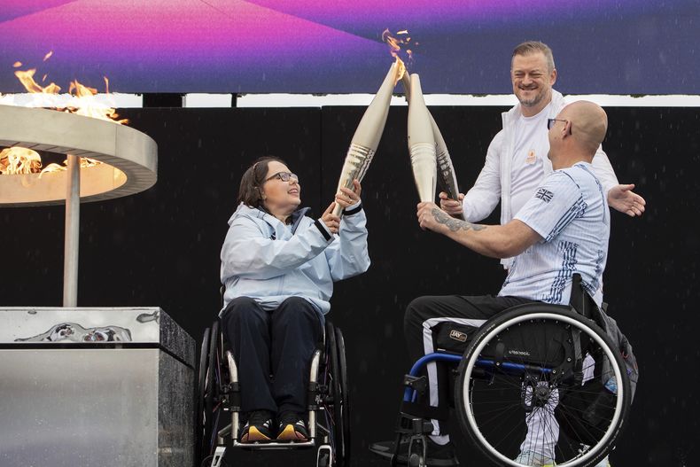 ARCHIVO - Los atletas paralímpicos británicos Helene Raynsford y Gregor Ewan encienden la llama paralímpica en Stoke Mandeville, ampliamente considerado el lugar de nacimiento de los Juegos Paralímpicos, Inglaterra, el sábado 24 de agosto de 2024. Los Juegos Paralímpicos se inaugurarán el miércoles cuando unos 4.400 atletas con discapacidades, lesiones permanentes o discapacidades se preparan para competir por 549 medallas en 22 deportes durante 11 días en París. (AP Foto/Thomas Krych, Archivo)