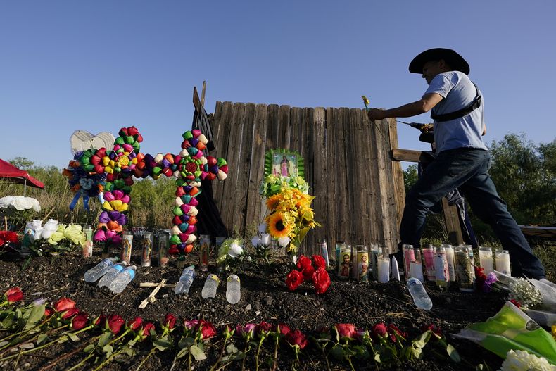 Archivo - Roberto Márquez, de Dallas, coloca una flor en un monumento improvisado en el lugar donde las autoridades encontraron a decenas de personas muertas en un remolque abandonado con migrantes, el 29 de junio de 2022, en San Antonio, Texas. La fiscalía federal mexicana informó el jueves 24 de octubre de 2024 de la detención en el estado de Tamaulipas, fronterizo con Estados Unidos, de un hombre vinculado con la muerte de los 53 migrantes . (Foto AP/Eric Gay, Archivo)
