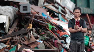 americateve | Tras el paso del tifón Haiyan, comienza a llegar ayuda para los damnificados en Filipinas. Un superviviente del tifón Haiyan permanece de pie en silencio entre las casas dañadas en la ciudad de Tacloban, Filipinas, el lunes 11 de noviembre de 2013. (Foto