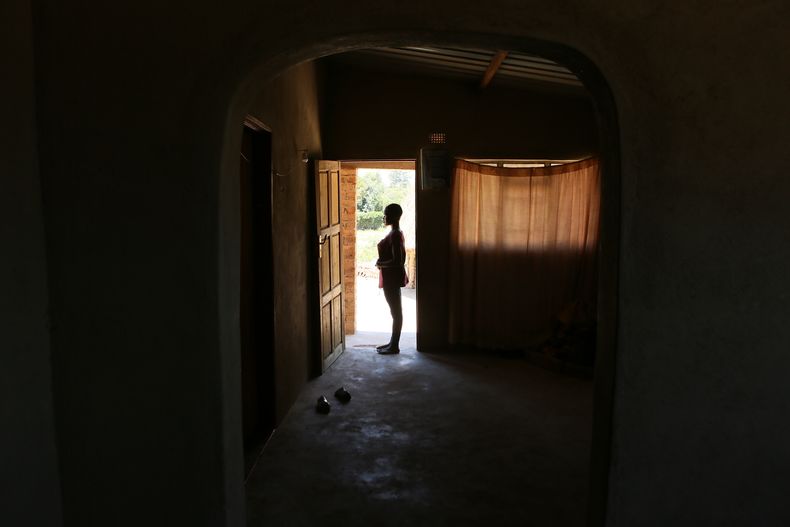 ARCHIVO - Virginia Mavhunga, una madre de 13 años, se ve en la entrada de su casa en Murehwa, 80 kilómetros (50 millas) al nordeste de la capital de Zimbabue, Harare, el viernes 10 de diciembre de 2021. (AP Foto/Tsvangirayi Mukwazhi, Archivo)