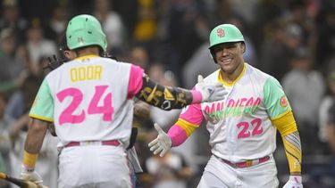 El dominicano Juan Soto, de los Padres de San Diego, es felicitado por su compañero venezolano Rougned Odor (24) después de que conectara un jonrón de dos carreras a los Nacionales de Washington en la octava entrada del partido en San Diego, el viernes 23 de junio de 2023. (AP Foto/Denis Poroy)