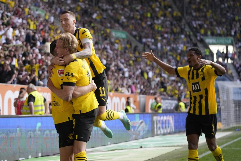 Jugadores del Borussia Dortmund celebran el gol de Julian Brandt ante el Augsburg en la Bundesliga el domingo 21 de mayo del 2023. (AP Foto/Matthias Schrader)