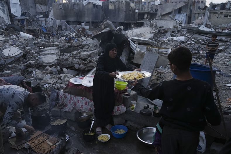 Miembros de la familia Marouf cocinan afuera de su casa, la cual fue destruida por ataques del ejército israelí, en Jabaliya, en la Franja de Gaza, el lunes 17 de marzo de 2025. (AP Foto/Jehad Alshrafi)