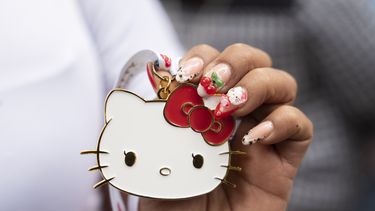 Una fan del personaje japonés Hello Kitty muestra una medalla del personaje creado por Yuko Shimizu, durante la celebración del 50 aniversario, en la Ciudad de México, el domingo 13 de octubre de 2024. (AP Photo/Aurea Del Rosario)