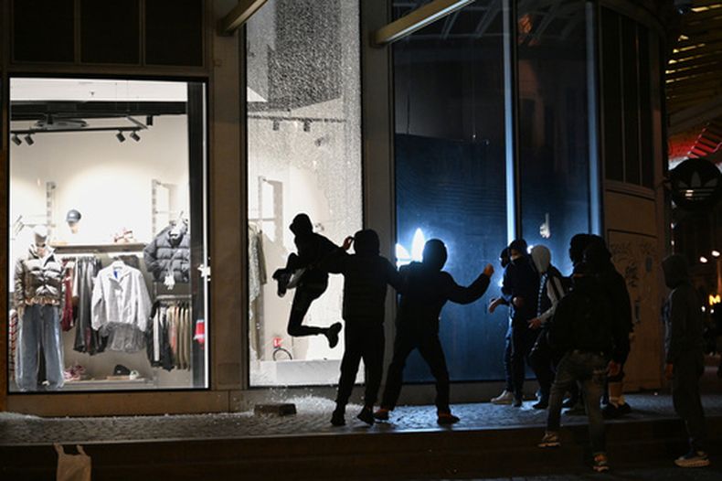 Jóvenes rompen el escaparate de una tienda durante enfrentamientos entre manifestantes y policías en País, el domingo 18 de octubre de 2026. (AP Foto/Emma Da Silva)