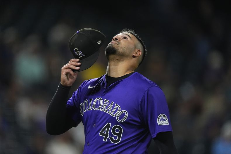 El lanzador abridor venezolano de los Rockies de Colorado, Antonio Senzatela se dirige hacia el dugout tras ser sacado del montículo en el cuarto episodio del juego de béisbol ante los Diamondbacks de Arizona, el lunes 16 de septiembre de 2024, en Denver. (AP Foto/David Zalubowski)