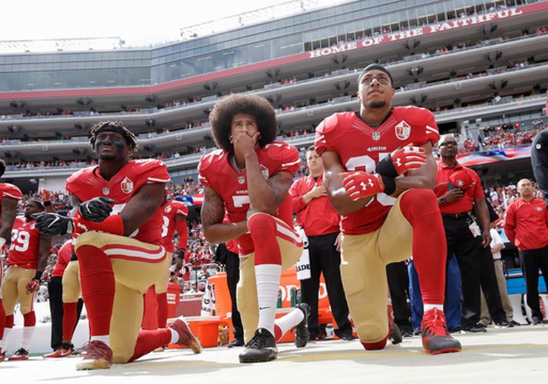 ARCHIVO - En esta fotografía de archivo del 2 de octubre de 2016, de izquierda a derecha, el apoyador externo de los 49ers de San Francisco Eli Harold, el mariscal de campo Colin Kaepernick y el profundo Eric Reid se arrodillan durante el himno nacional antes de un partido de fútbol americano de la NFL contra los Cowboys de Dallas en Santa Clara, California. (Foto AP/Marcio Jose Sanchez, Archivo)