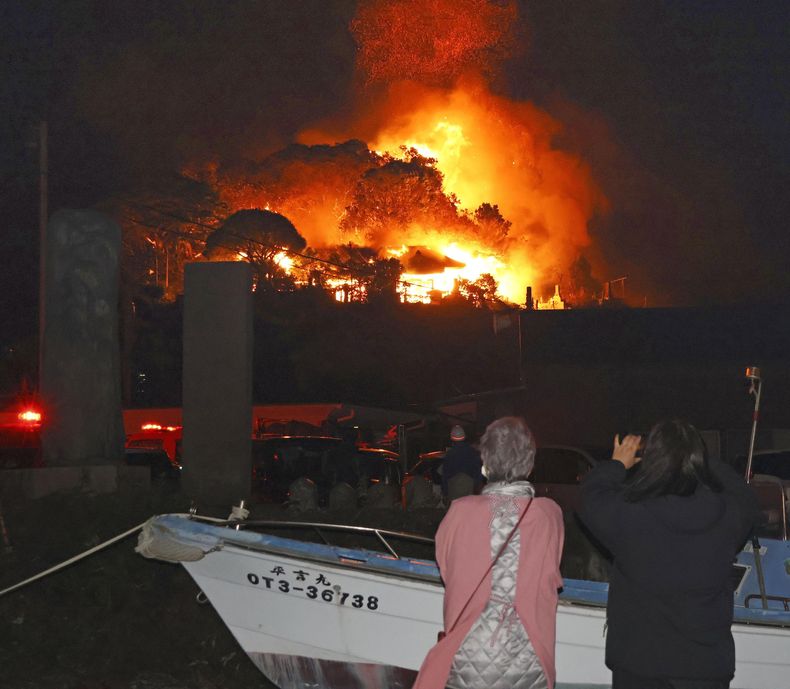 Residentes observan las llamas de un incendio, el martes 18 de noviembre en Oita, en el sur de Japón. (Kyodo News vía AP)