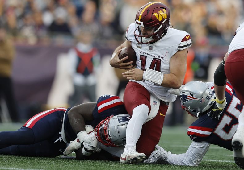 El quarterback de los Commanders de Washington Sam Howell es capturado por el linebacker de los Patriots de Nueva Inglaterra JaWhaun Bentley en el encuentro de la NFL del domingo 5 de noviembre del 2023. (AP Foto/Michael Dwyer)