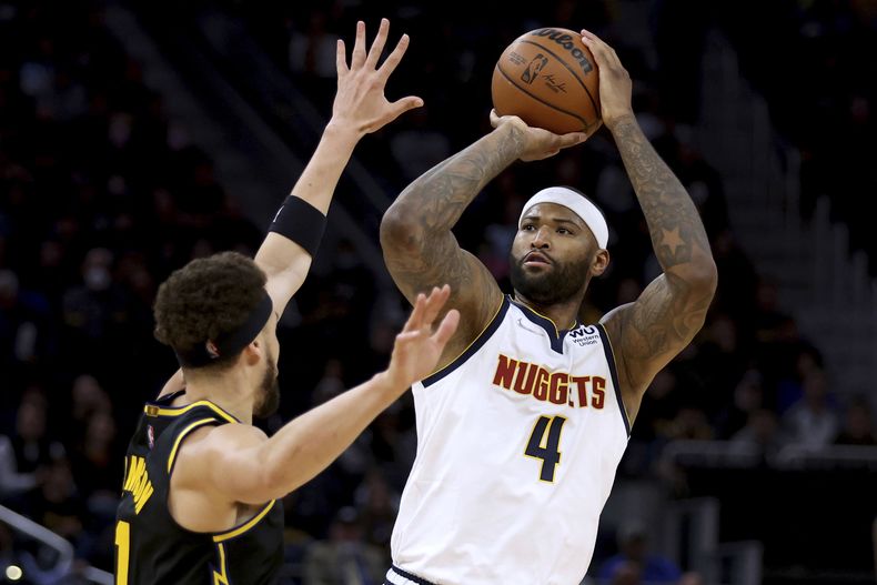 ARCHIVO - DeMarcus Cousins (4) de los Nuggets de Denver dispara al aro frente a Klay Thompson (izquierda) de los Warriors de Golden State, el miércoles 27 de abril de 2022. (AP Foto/Jed Jacobsohn)