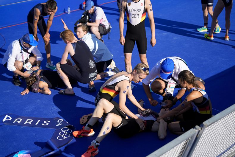 Los alemanes Tim Hellwig (2A), Lisa Tertsch (2B) y Laura Lindemann (2D) celebran tras ganar el triatlón mixto de los Juegos Olímpicos de París, el lunes 5 de agosto de 2024. (AP Foto/David Goldman)