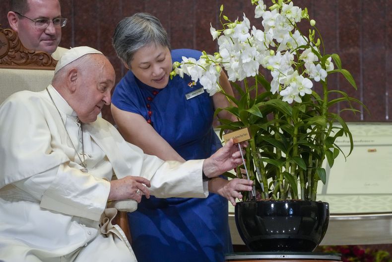 La directora general de la Junta de Parques Nacionales de Singapur, Hwang Yu-Ning, presenta al papa Francisco una Dendrobium His Holiness Pope Francis, una orquídea cultivada especialmente y que leva su nombre, en el parlamento de Singapur, el jueves 12 de septiembre de 2024. (AP Foto/Gregorio Borgia)