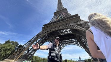 La policía evacúa los alrededores de la Torre Eiffel luego que un individuo fue visto escalando el icónico monumento de París, el domingo 11 de agosto de 2024. (AP Foto/Aijaz Rahi)
