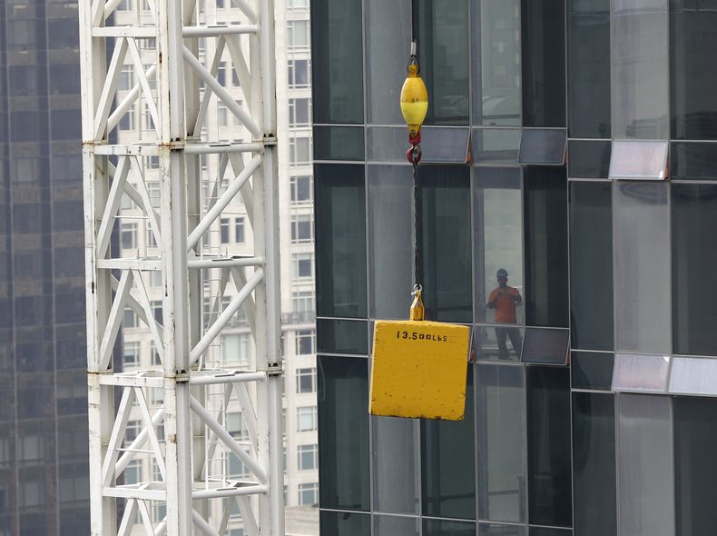 Un hombre observa una carga atorada que qued&oacute; suspendida sobre una calle de la ciudad de Nueva York, el lunes 7 de octubre de  2013. (Foto AP/Seth Wenig)