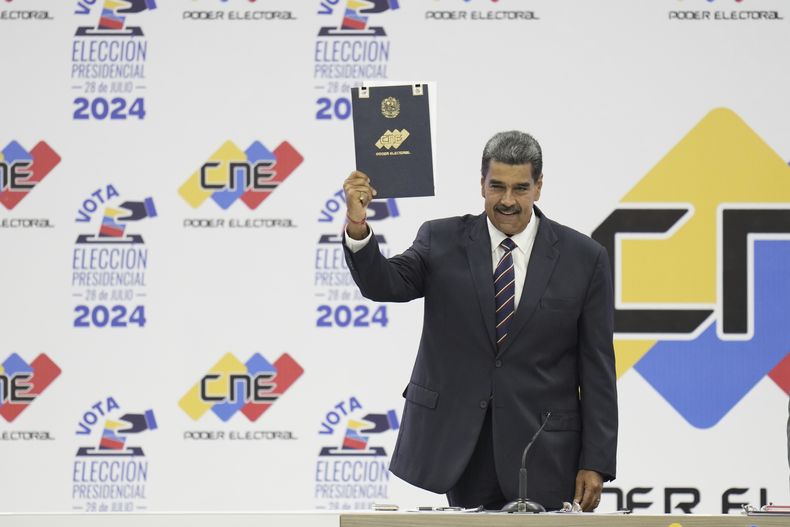 El presidente venezolano Nicolás Maduro sostiene su certificación del Consejo Nacional Electoral (CNE) que lo declara ganador de las elecciones presidenciales en Caracas, Venezuela, el lunes 29 de julio de 2024. (AP Foto/Matías Delacroix)