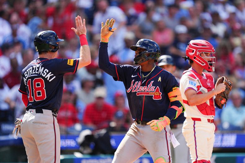 El venezolano Ronald Acuña Jr., de los Bravos de Atlanta (centro), choca la mano con Mike Yastrzemski (izquierda) tras conectar un jonrón de tres carreras ante el lanzador de los Filis de Filadelfia, Alex McFarlane, durante la octava entrada de un partido de béisbol, el domingo 6 de septiembre de 2026, en Filadelfia.