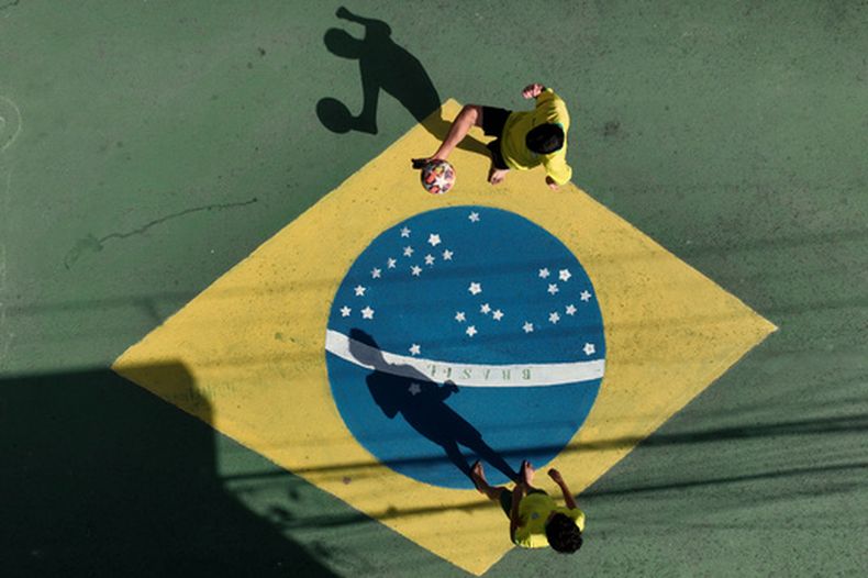 Un grupo de niños juega al fútbol sobre una calle de Osasco, el viernes 5 de junio de 2026, en la zona metropolitana de Sao Paulo. (AP Foto/Andre Penner)