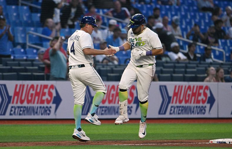 El coach de tercera base de los Rays de Tampa Bay, Brady Williams (4), y el mexicano Jonathan Aranda, a la derecha, celebran tras el jonrón de Aranda durante la sexta entrada de un partido de béisbol contra los Mellizos de Minnesota, el viernes 24 de abril de 2026, en St. Petersburg, Florida. (AP Foto/Jason Behnken)