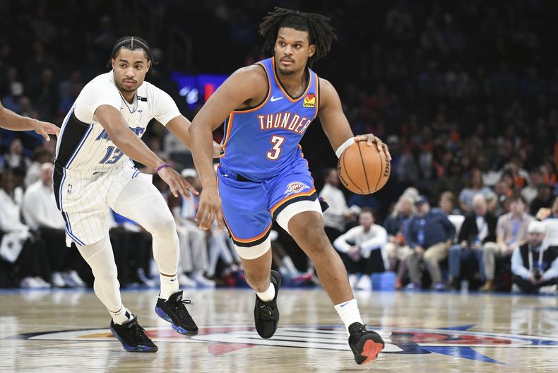 Dillon Jones (3), del Thunder de Oklahoma City, conduce el balón pasando a Jett Howard (13), del Magic de Orlando, durante la segunda mitad del juego de baloncesto de la NBA, el lunes 4 de noviembre de 2024, en Oklahoma City. (AP Foto/Kyle Phillips)