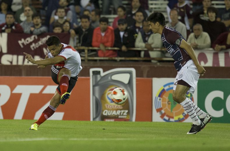 El colombiano Te&oacute;filo Guti&eacute;rrez, de River Plate, dispara frente a Paolo goltz, de Lan&uacute;s, durante el partido de ida de los octavos de final de la Copa Sudamericana, disputado el martes 29 de octubre de 2013, en Buenos Aires (AP Foto/Ed
