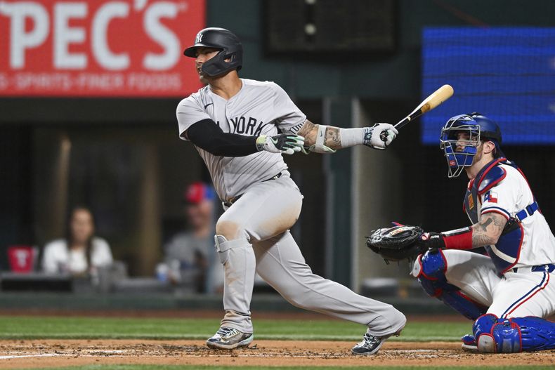 Gleyber Torres, izquierda, de los Yankees de Nueva York, sigue con la mirada un doble productor de dos carreras en la tercera entrada del juego de béisbol en contra de los Rangers de Texas, el lunes 2 de septiembre de 2024, en Arlington, Texas. (AP Foto/Albert Pena)