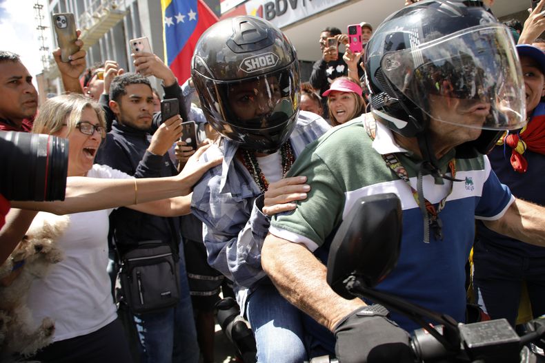La líder opositora María Corina Machado es trasladada en motocicleta al final de una manifestación en Caracas, Venezuela, el sábado 3 de agosto de 2024. (Foto AP/Cristian Hernández)