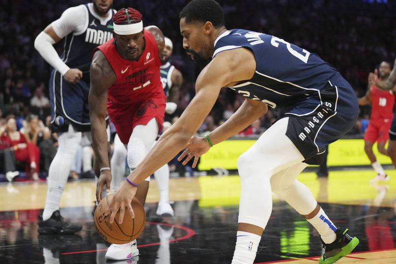 Jimmy Butler del Heat de Miami (22) lucha contra P.J. Washington (25) de los Mavericks de Dallas por un balón suelto durante la segunda mitad, el domingo 24 de noviembre de 2024, en Miami. (AP Foto/Jim Rassol)