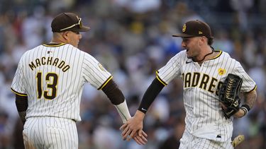 El bateador designado de los Padres de San Diego, Manny Machado (13), celebra con el jardinero central Jackson Merrill después de que los Padres derrotaron 4-0 a los Bravos de Atlanta el sábado 13 de julio de 2024, en San Diego. (AP Foto/Gregory Bull)
