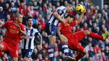 americateve | Luis Su&aacute;rez (der) pelea un bal&oacute;n con Gareth McAuley durante el partido que Liverpool le gan&oacute; 4-1 al West Bromwich Albion con tres tantos del uruguayo el 26 de octubre del 2013. Su&aacute;rez fue elegido el mejor jugador de la semana e