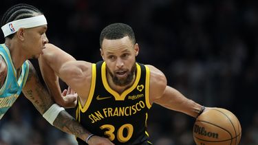 Stephen Curry, de los Warriors de Golden State, conduce el balón hacia la canasta pasando al lado de Tre Mann, de los Hornets de Charlotte, durante la primera mitad del juego de baloncesto de la NBA, el viernes 29 de marzo de 2024, en Charlotte, Carolina del Norte. (AP Foto/Chris Carlson)