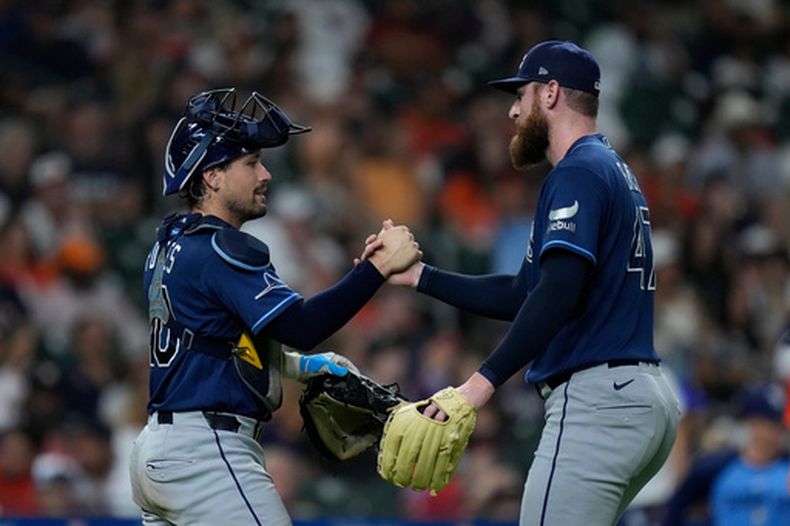 El receptor Nick Fortes y el lanzador Bryan Baker, de los Rays de Tampa Bay, celebran tras un partido de béisbol contra los Astros de Houston, el viernes 3 de julio de 2026, en Houston. (Foto AP/Kevin M. Cox)