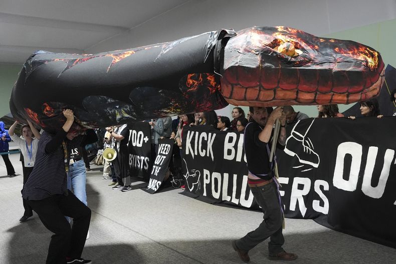 Kevin Buckland (derecha) y otros activistas participan en una manifestación contra los combustibles fósiles en la cumbre climática de Naciones Unidas, COP29, en Bakú, Azerbaiyán, el 15 de noviembre de 2024. (AP Foto/Joshua A. Bickel)