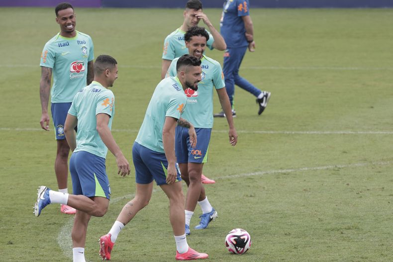 El brasileño Alex Telles, centro, Marquinhos, centro derecha, y sus compañeros de equipo entrenan antes de un partido de fútbol clasificatorio para la Copa del Mundo 2026 contra Chile en Sao Paulo, el miércoles 9 de octubre de 2024. (AP Foto/Ettore Chiereguini)