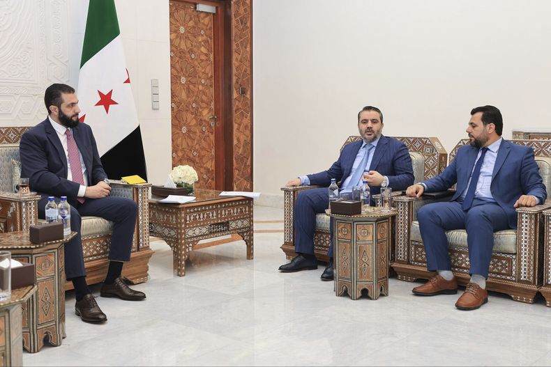 Foto difundida por la agencia de noticias siria SANA que muestra al presidente sirio interino Ahmad al-Sharaa (izq) con el ministro sirio de exteriores Asaad al-Shibani (cent) y Mohammed Taha al-Ahmad, presidente del Alto Comité para las Elecciones de la Asamblea del Pueblo, en Damasco, Siria, el 27 de julio del 2025. (SANA via AP)