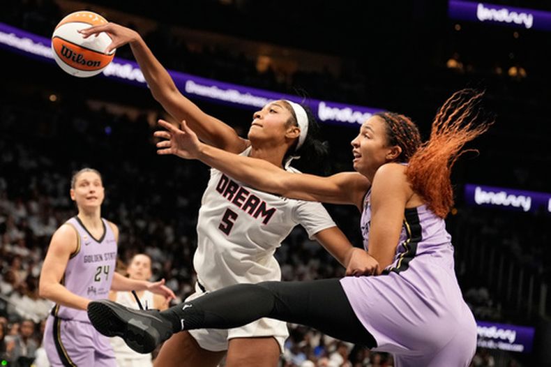 Angel Reese (5) del Dream de Atlanta recupera un rebote ante Kiah Stokes (4) de las Golden State Valkyries en el cuarto partido de las Finales de la WNBA, el 24 de octubre de 2026, en Atlanta. (AP Foto/Brynn Anderson)