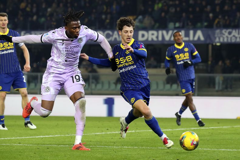 Kingsley Ehizibue, izquierda, de Udinese, y Daniele Ghilardi, de Hellas Verona, disputan un balón durante un partido de fútbol de la Serie A entre Hellas Verona y Udinese en el estadio Marcantonio Bentegodi, el sábado 4 de enero de 2025, en Verona, Italia. (Paola Garbuio/LaPresse via AP)