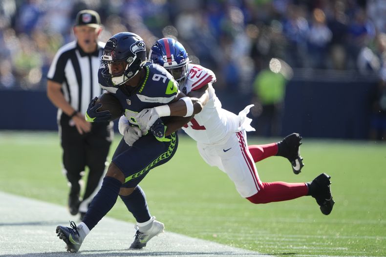 Kenneth Walker III (9), running back de los Seahawks de Seattle, es derribado fuera del campo por el safety Tyler Nubin (31), de los Giants de Nueva York, durante la segunda mitad del partido de la NFL, el domingo 6 de octubre de 2024, en Seattle. (AP Foto/Lindsey Wasson)