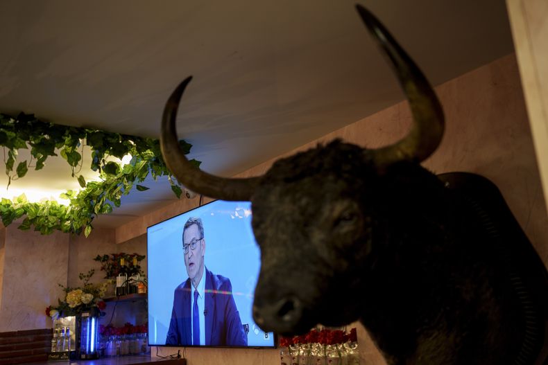 El líder del conservador Partido Popular, Alberto Núñez Feijóo, se ve en una pantalla de televisión en un bar durante un debate en vivo con el presidente del gobierno y líder del PSOE, Pedro Sánchez, en Madrid, España, el lunes 10 de julio de 2023. (AP Foto/Manu Fernández)