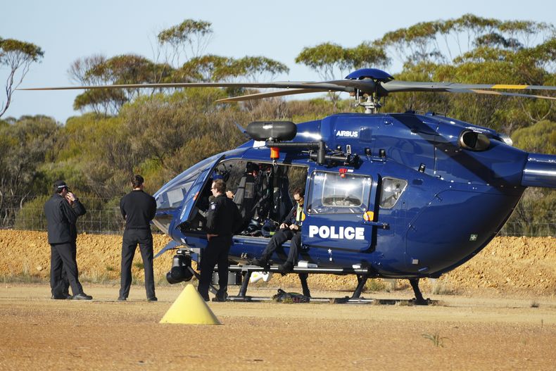 Policías esperan junto a un helicóptero en Beacon, Australia Occidental, el viernes 11 de julio de 2025, al tiempo que se preparan para buscar a la mochilera alemana desaparecida Carolina Wilga. (ABC News vía AP)